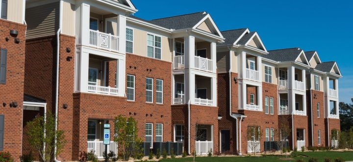 A row of multi-story apartment buildings with brick and siding exteriors, clean balconies, and well-maintained landscaping, showcasing the results of professional commercial pressure washing services in Toledo, OH.